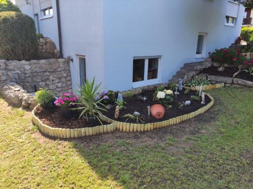 a garden in front of a house with flowers at Ferienwohnung Kemmerth in Ebermannstadt