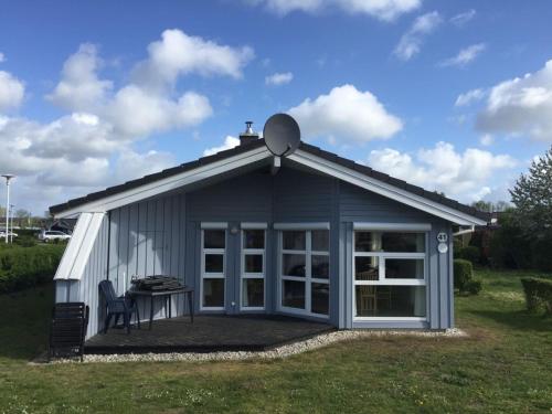 a small shed with a table in a yard at Ferienhaus Strandpark 41 in Grömitz