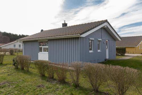 a gray house with a roof on a yard at Ferienhaus Strandpark 41 in Grömitz