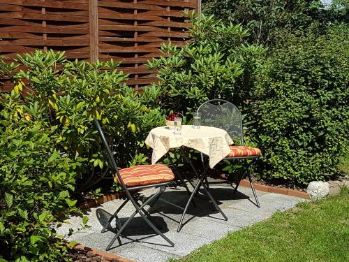 a table and two chairs sitting at a table in a garden at Ferienwohnung Inge Grahl in Lenz
