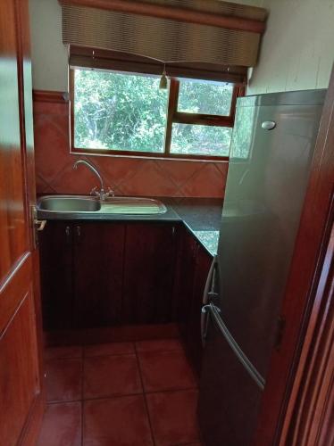 a small kitchen with a sink and a refrigerator at Vaal River Front Lodge in Sasolburg