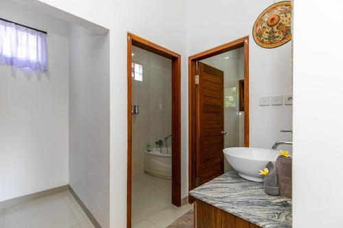 a bathroom with a sink and a toilet and a tub at Villa Aniela Legian in Legian