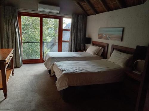 a hotel room with two beds and a window at Vaal River Front Lodge in Sasolburg
