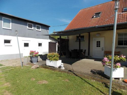 a house with two potted plants in a yard at Ferienwohnung Mohnblume in Gerswalde