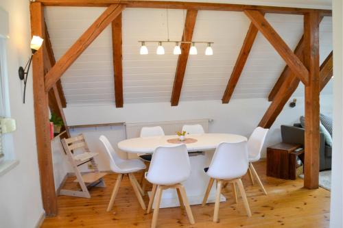 a dining room with a white table and white chairs at Ferienwohnung "ZU HAUSE" in Guben