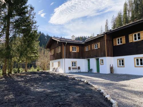 a large wooden house with a driveway in front of it at Mitteralm-Kreuth in Kreuth