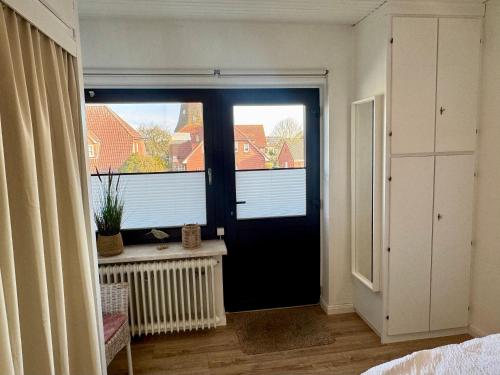 a room with a black door and a window at Haus Lith - Ferienwohnung Strandläufer in Nordstrand