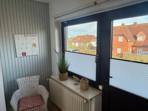 a room with a window and a chair and a radiator at Haus Lith - Ferienwohnung Strandläufer in Nordstrand