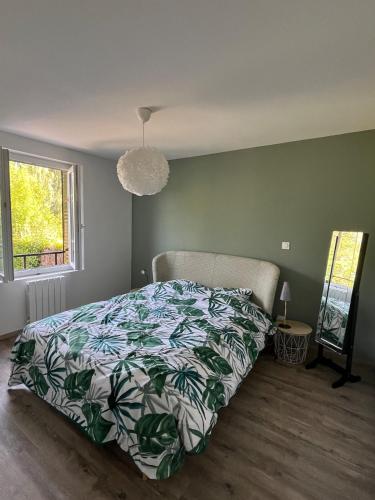 a bedroom with a bed with a green wall at Chez Paulette - par Happy House in Gouzon