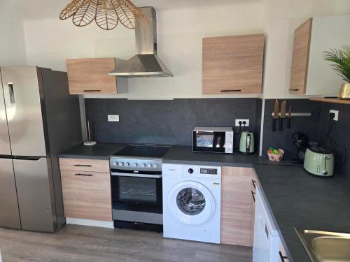 a kitchen with a washing machine and a refrigerator at Casa Lumina in Lachapelle-sous-Rougemont