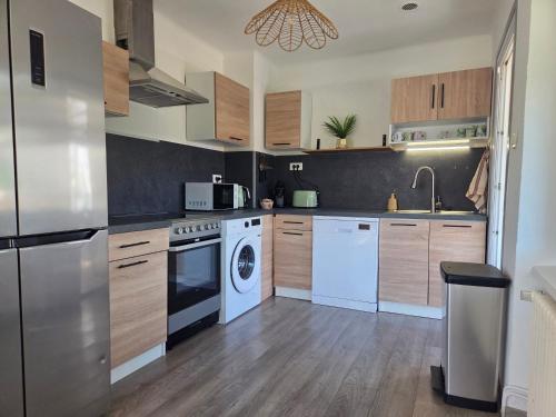 a kitchen with white appliances and wooden cabinets at Casa Lumina in Lachapelle-sous-Rougemont