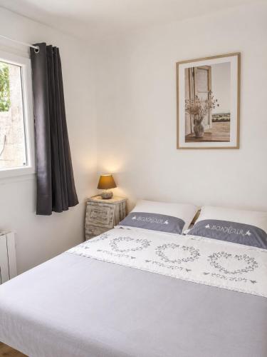 a bedroom with a white bed and a window at Chambre Cocon, bienvenue chez Sylviane in Marennes
