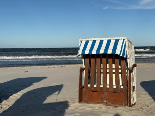 a beach chair with an umbrella on the beach at Villa Eden II in Binz