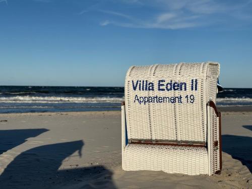 a white beach chair sitting on the beach at Villa Eden II in Binz