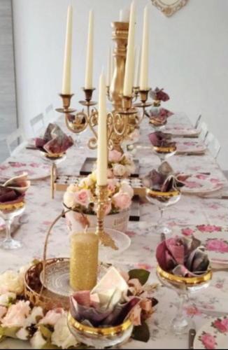 a long table with candles and plates on it at Jetset Parisian Holiday Home in Cesson