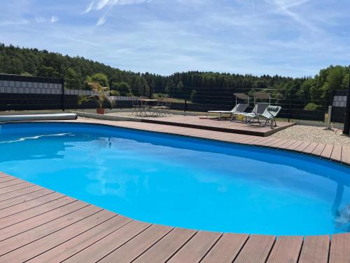 a large blue swimming pool on a wooden deck at Ennerla Hof in Pottenstein