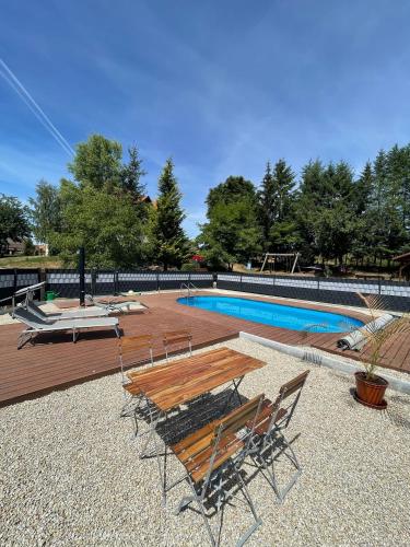 a picnic table and chairs next to a swimming pool at Ennerla Hof in Pottenstein