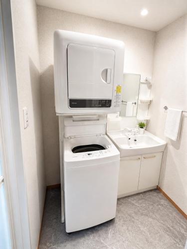 a small bathroom with a tv on top of a stove at 一棟貸切の民宿 月 駐車場2台無料 バス停徒歩1分 市街地へ好アクセス in Matsuyama