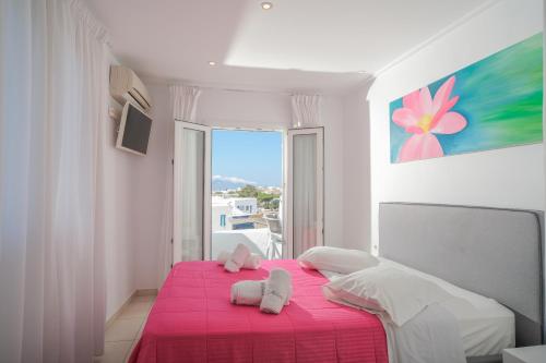 ein Schlafzimmer mit einem rosa Bett und einer rosa Decke in der Unterkunft Hotel Milena in Mykonos Stadt