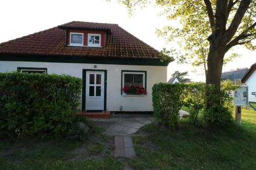 a small white house with a window and a door at Ferienwohnung bei Antje Timm in Hiddensee
