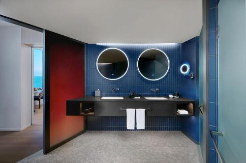 a bathroom with two sinks and two mirrors at Hard Rock Hotel Pattaya in Pattaya