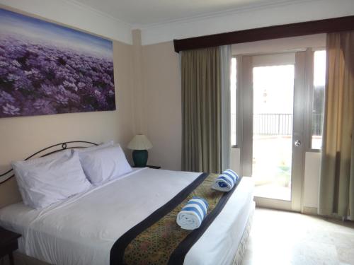 勒吉安的住宿－Private Apartments at Jayakarta Resort，一间卧室设有一张床和一个大窗户