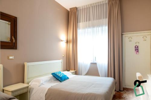 a hotel room with two beds and a window at Hotiday Porto Cesareo Spiaggia in Porto Cesareo