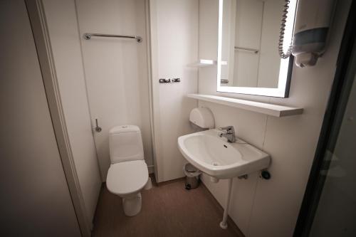 a small bathroom with a toilet and a sink at Blix Hotel in Vikøyri