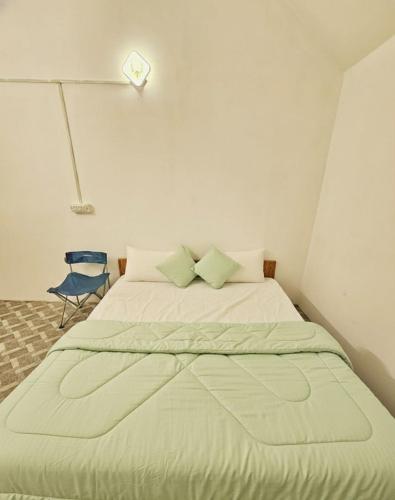 a large bed in a room with a blue chair at The Canvo Vattavada Private Cottages in Vattavada