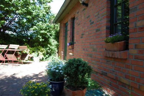 a brick building with potted plants on the side of it at Ferienwohnungen Meyer in Bollewick