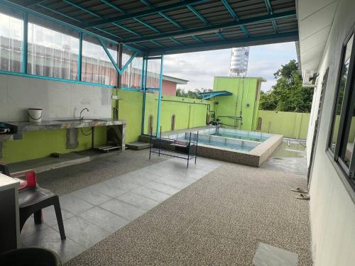 a large room with a pool and a sink and a building at Homestay Abah in Bidur