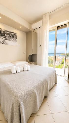 un dormitorio con una cama grande y una ventana grande en Hotel Amedea, en Cervia