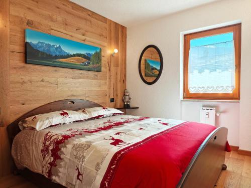 a bedroom with a bed with a red blanket at Il Nido al Noce in Morgex