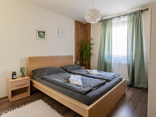 a bedroom with a bed with two towels on it at Six Corners Garden Corner with Terrace and Parking in Pécs
