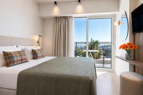 a hotel room with a bed and a large window at Metaxa Hotel Heraklion - Urban Boutique Living in Heraklio