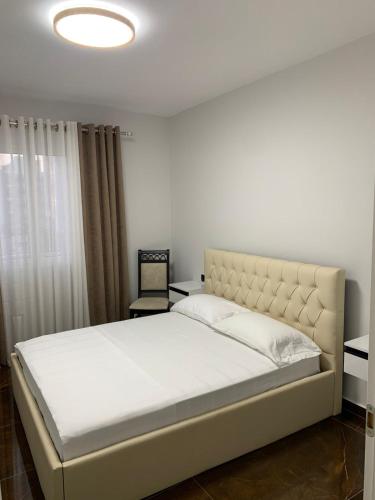 a bedroom with a large bed with white sheets and a window at Luna Mare Apartments in Orikum