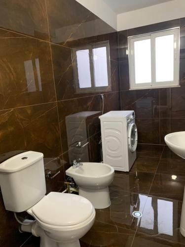 a bathroom with a toilet and a sink at Luna Mare Apartments in Orikum