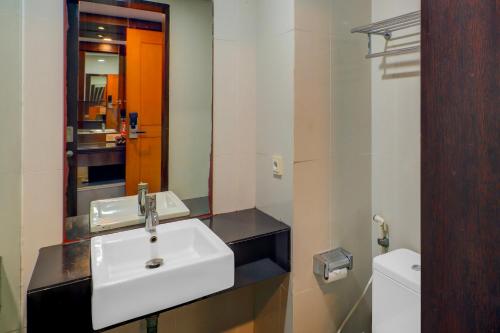 a bathroom with a white sink and a mirror at Palette Hotel Seminyak in Seminyak
