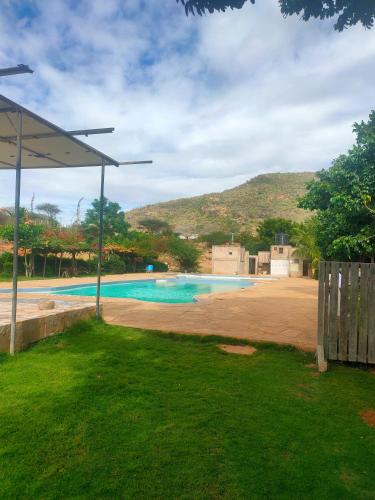 a swimming pool in a yard with a hill in the background at Sere n' Lukundo Park & Camping Services in Voi