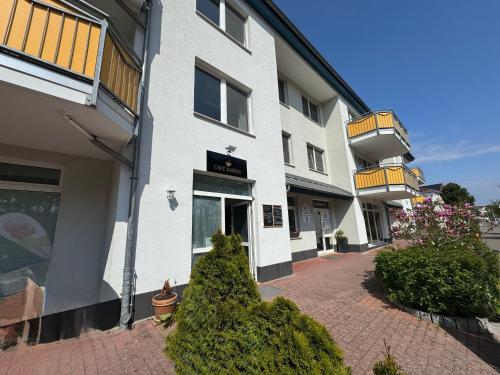 a white apartment building with a brick walkway at Ferienwohnung Quartier18-09 strandnah in Karlshagen