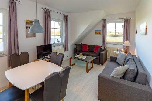 a living room with a couch and a table at Reethaus Boddenblick in Alt Reddevitz - Wohnung 4 in Mariendorf