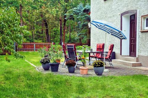 a patio with chairs and a table with an umbrella at Ferienwohnung Hänsch in Siedlung Adler