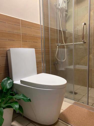 a white toilet in a bathroom with a shower at The Pine Lush Hideout in Baguio
