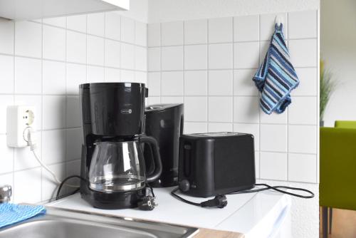 a kitchen counter with a coffeemaker and a coffee maker at GUWO Gästewohnung Platanenstraße 1 in Guben