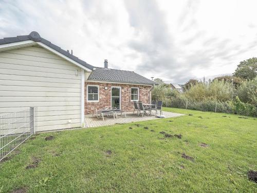 a brick house with a picnic table in a yard at Moderne Doppelhaushälfte - perfekt zu zweit in Dagebüll