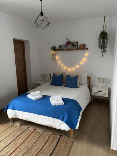 a bedroom with a blue and white bed with lights at Alaire Alojamiento in Algodonales