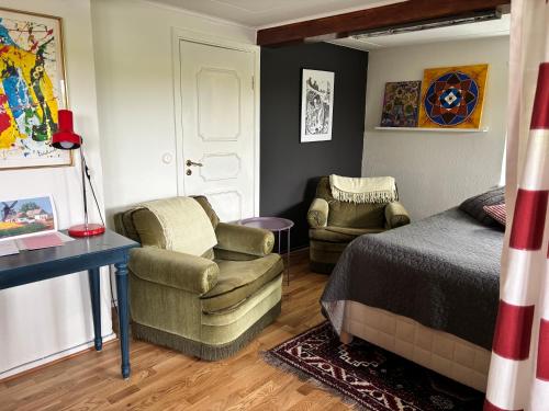 a bedroom with a bed and a chair and a desk at Sjörups Vera in Trelleborg