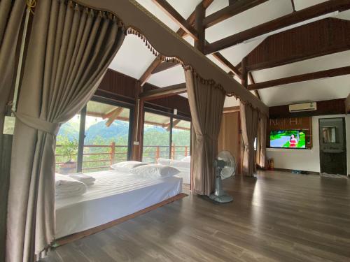 a bedroom with a bed in a room with a tv at Nest hill retreat in Mù Cang Chải