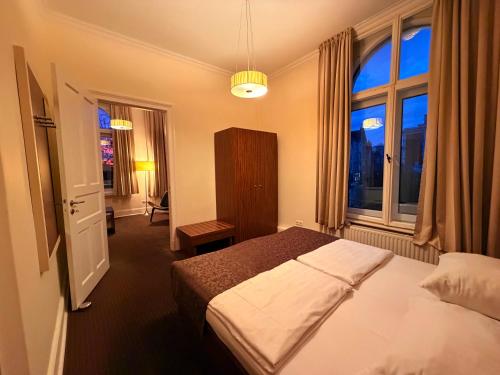 a bedroom with a bed and a large window at Hotel Excellent in Lübeck