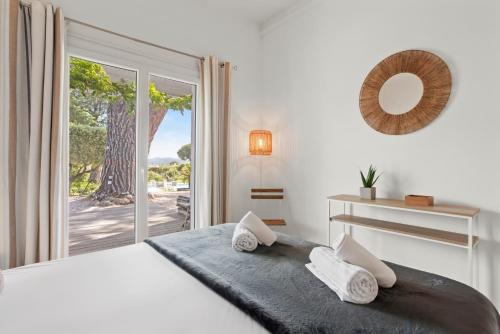 a bedroom with a bed and a large window at Villa Artemis piscine Golfe St-Trop in Grimaud